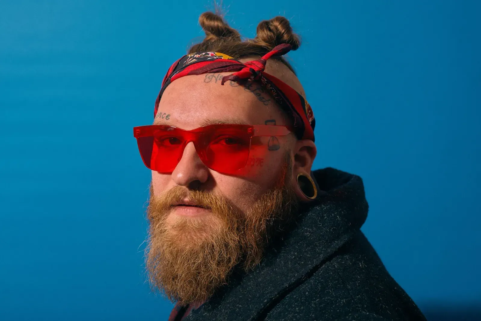 Profile of Teddy Swims wearing bright pink glasses