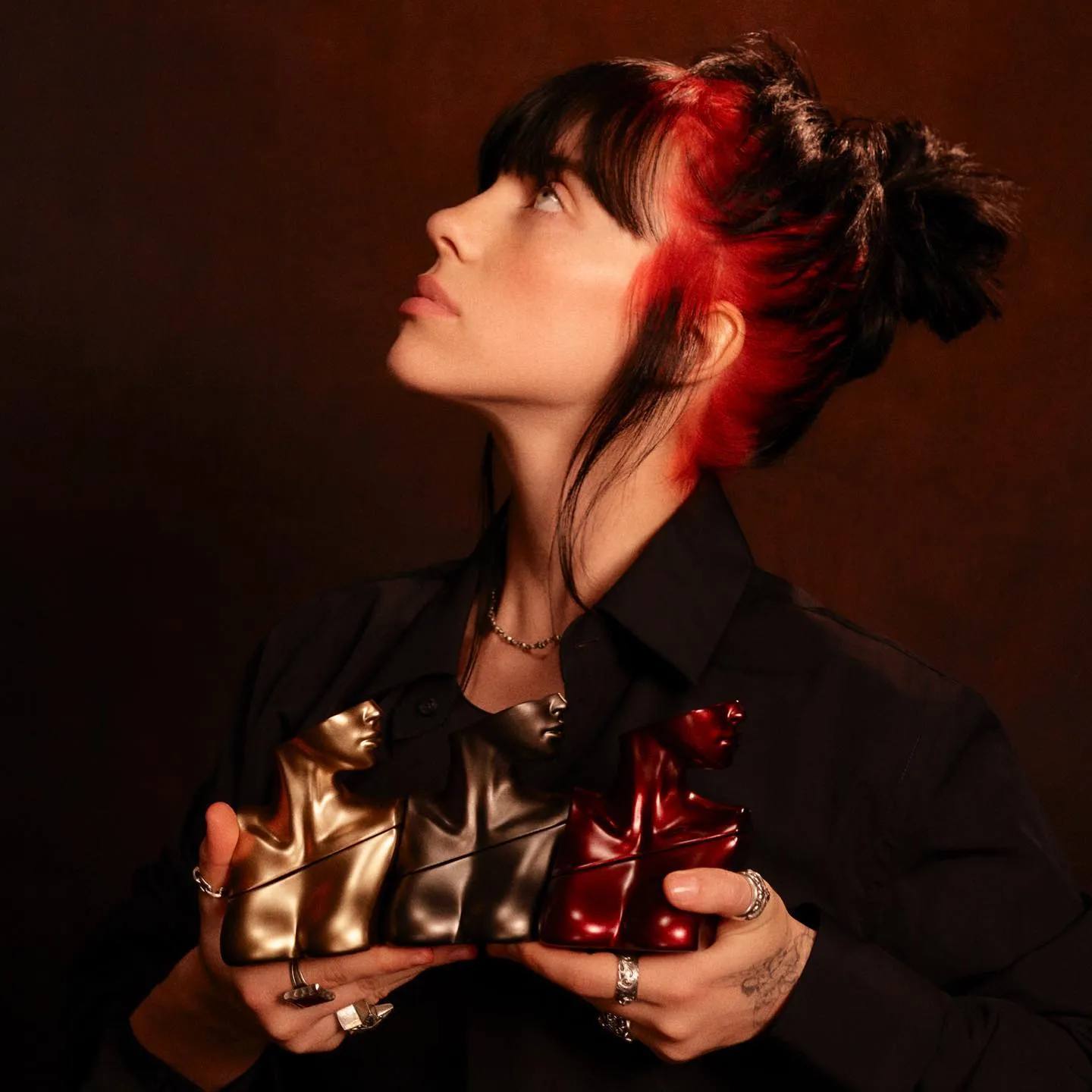 Billie Eilish holds all three perfumes form the 'Eilish' collection