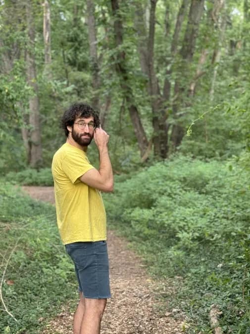 Joe Mygen, hiking in forest, jeans shorts, bright yellow t-shirt, Photo: Corinne Cooke