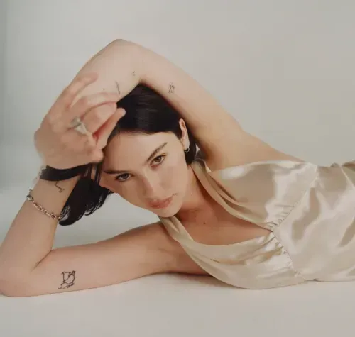 Gracie Abrams posing in ivory silk gown, short bob, via Interview.