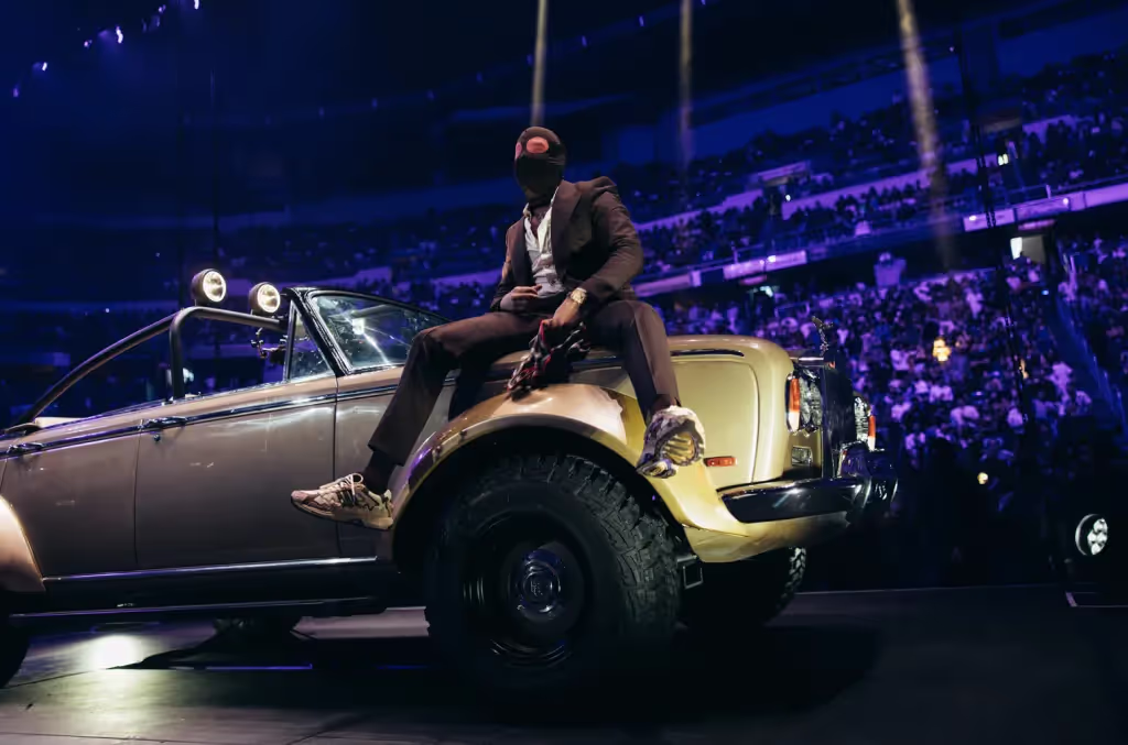 Bad Bunny wearing black suit and the mask, descended from the ceiling during the Nadie Sabe listening party