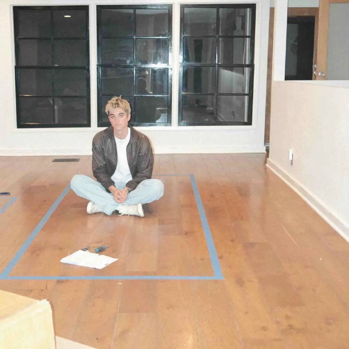 Elijah Woods' 'We Should Stick Together' (Acoustic) cover art features him sitting on the floor of an empty room.