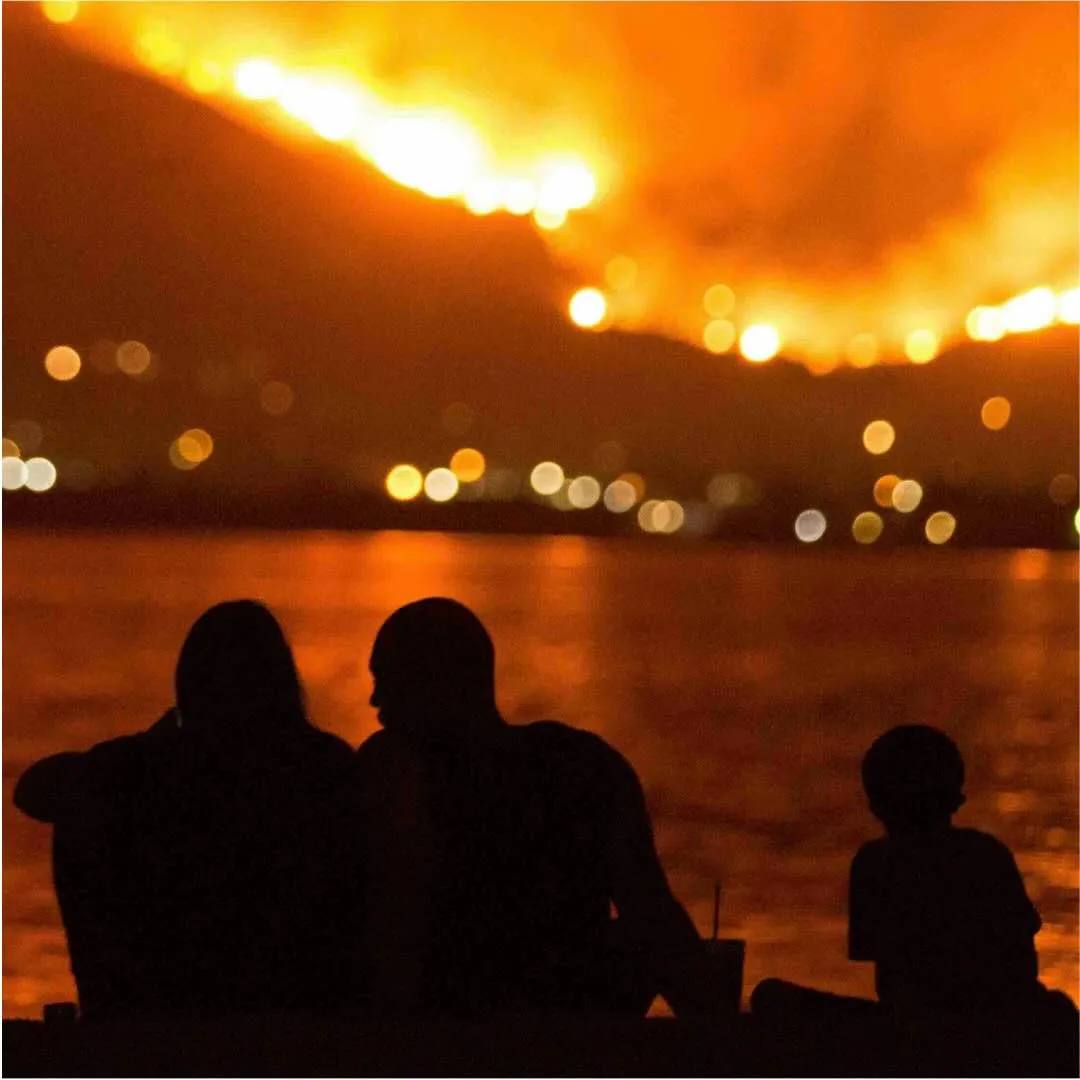 A family with a child watches Pacific Palisades Wildfire (Los Angeles, CA) from PCH.