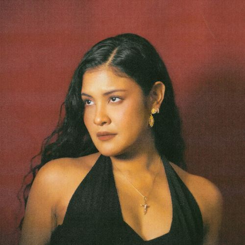 Portrait of Kiana V against a red backdrop.